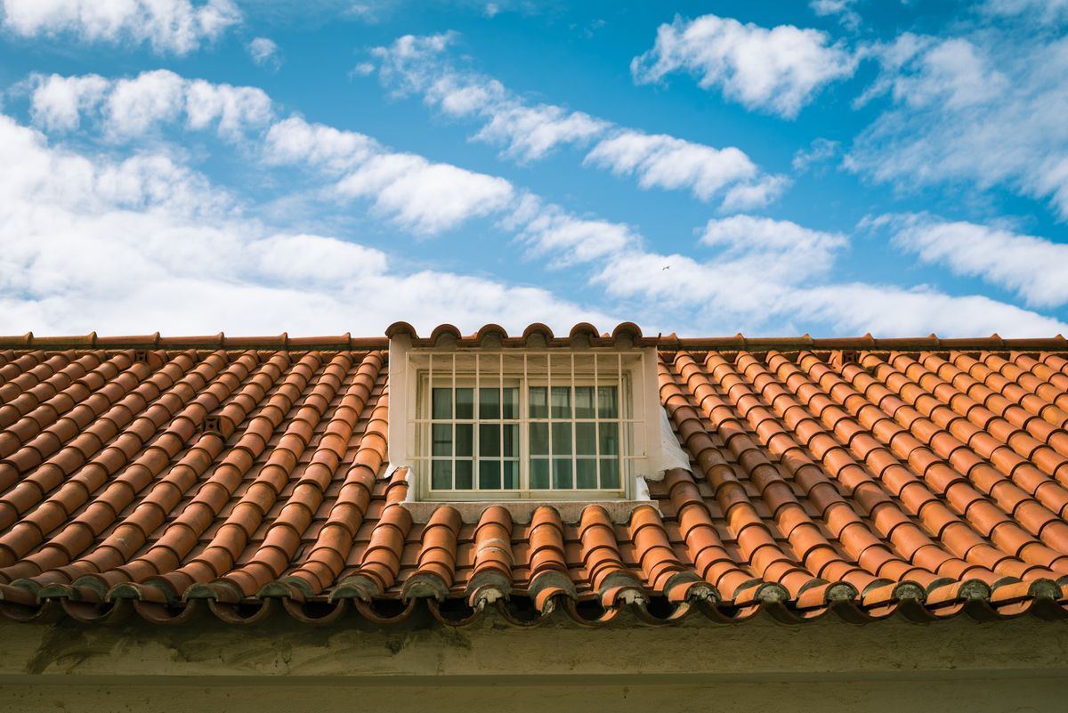 Toiture en tuiles neuves avec lucarne sous un ciel dégagé